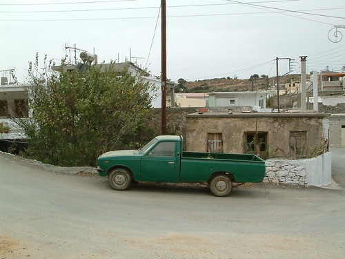 Green pickup sitting on a slope