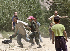 Aid workers play with Afghan kids