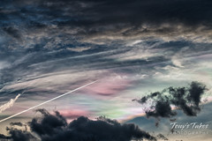 A plane flies 'through' iridescent clouds