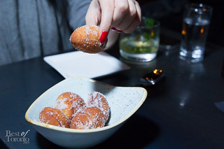 Bomboloni, raspberry-filled fritters with vanilla sugar coating.