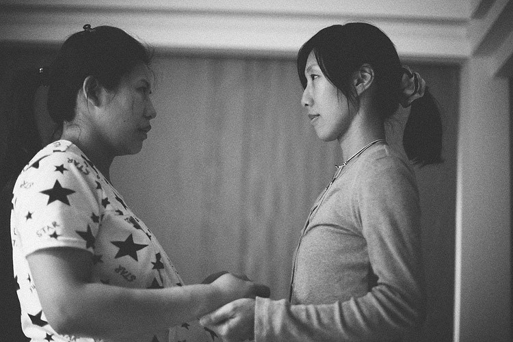 孕婦與助產師面對面站著握手，看著彼此。