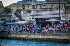 Summer time hanging on the banks of the Seine river is popular for locals and tourists.